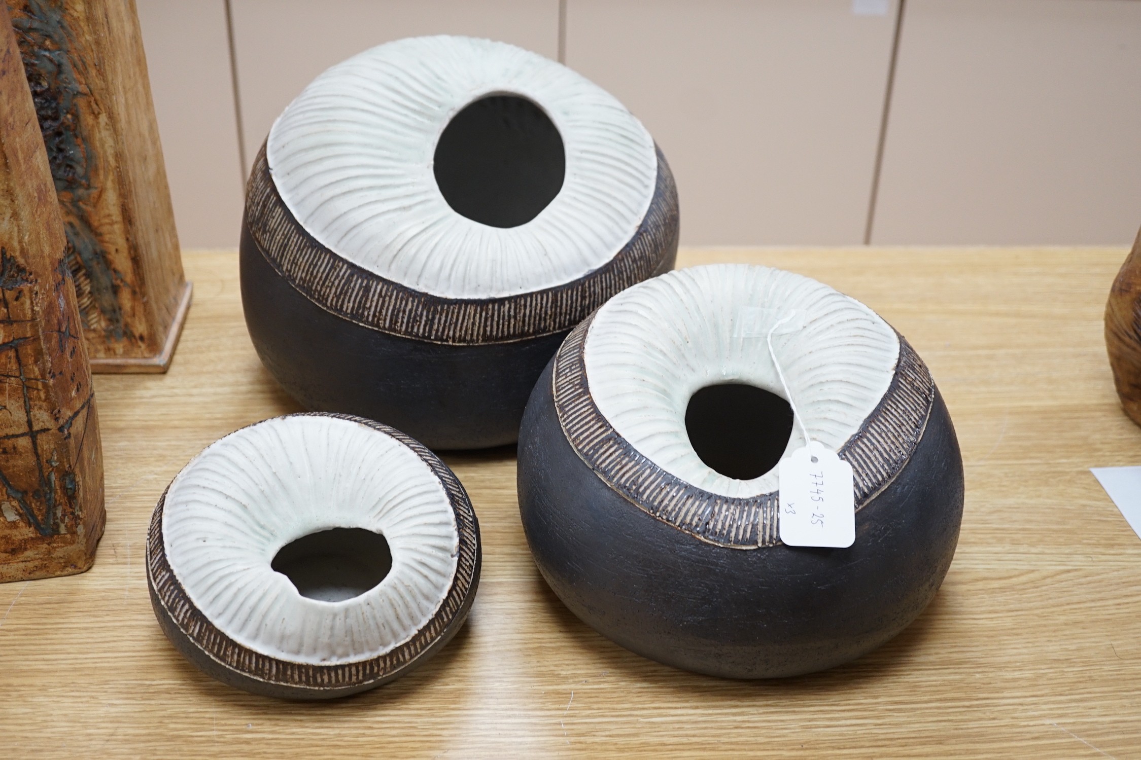 Ruth Sulke - a set of three graduated shell-like circular pottery vases, each inscribed R/S on base, tallest approximately 25cms high